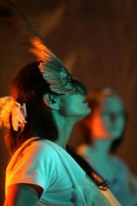 a person wearing a bird like mask over their eyes performing on stage