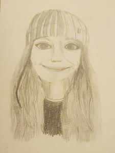 Pencil portrait of a girl on cream paper. She is smiling and has big eyes and a woolly hat on.