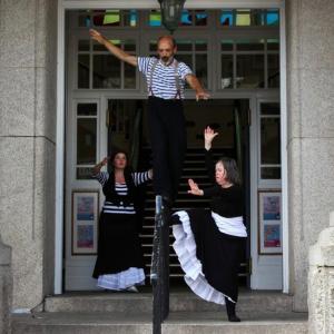 Three dancers in costume performing on the steps of Falmouth Library and Art Gallery