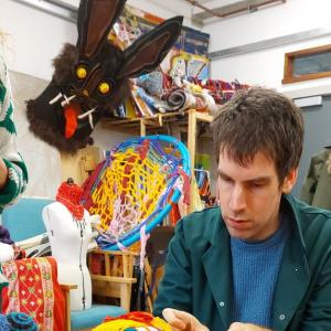 a person playing with colourful textile materials 