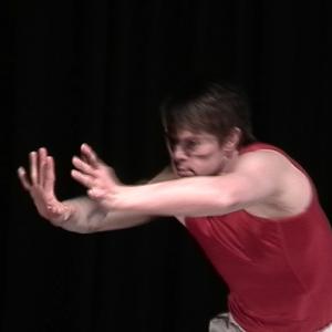 A person dancing with their arms stretch out in front of them. 