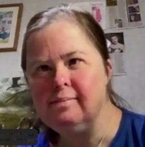 face of a woman smiling in blue top