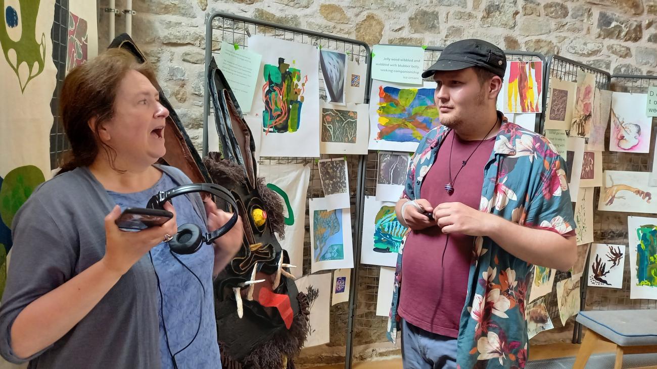 2 people talking at an art exhibition