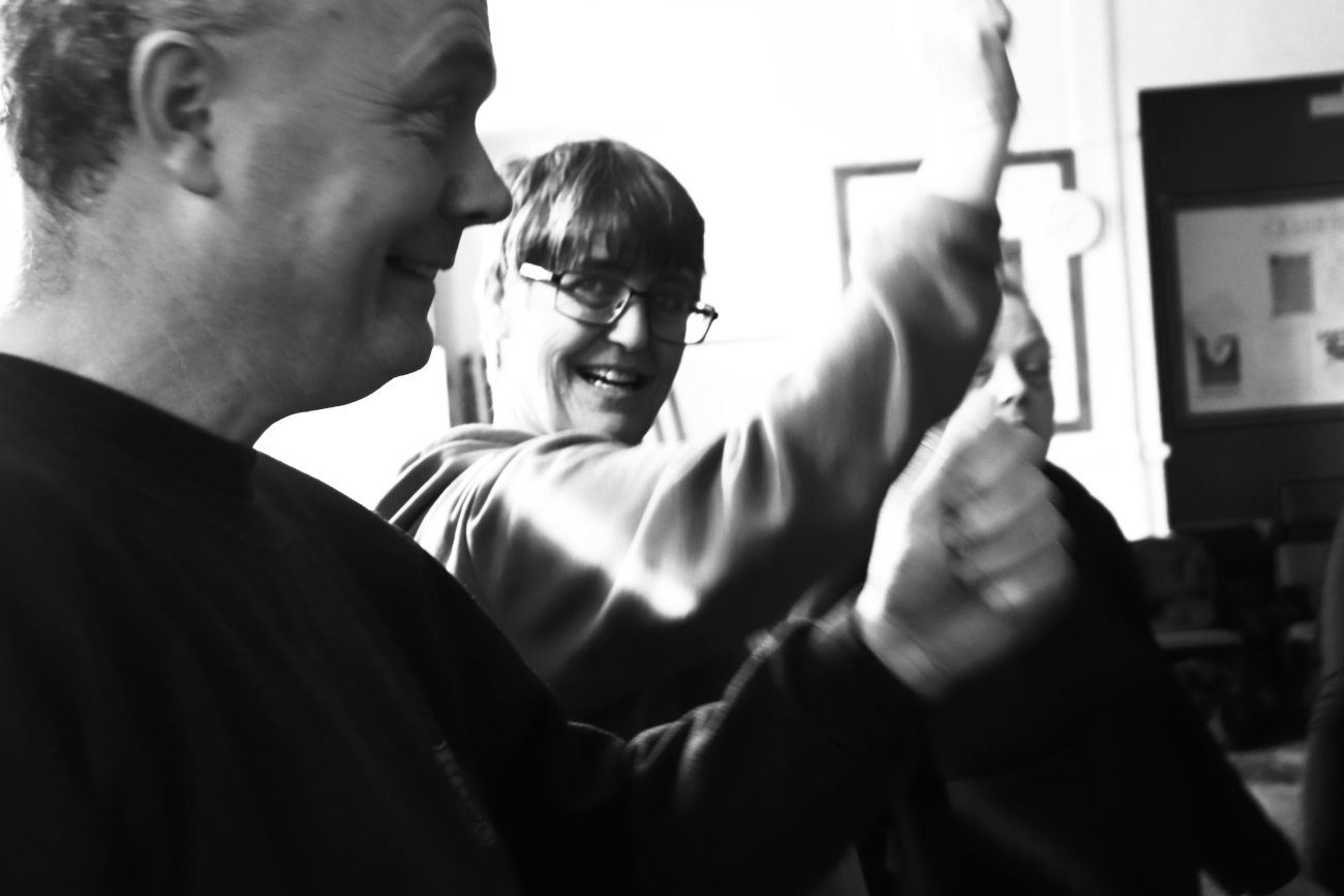 2 people dancing with their arms in the air