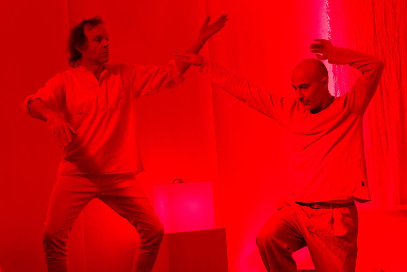 2 people dancing in a red lit space.
