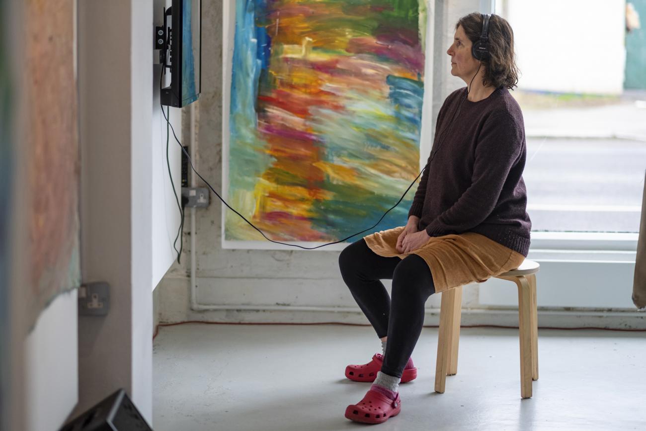 a person watching a film on the wall at Rise and Fall exhibition 