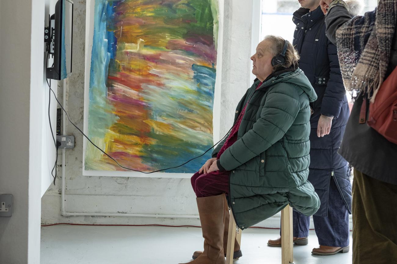 a person watching a film on the wall at Rise and Fall exhibition 
