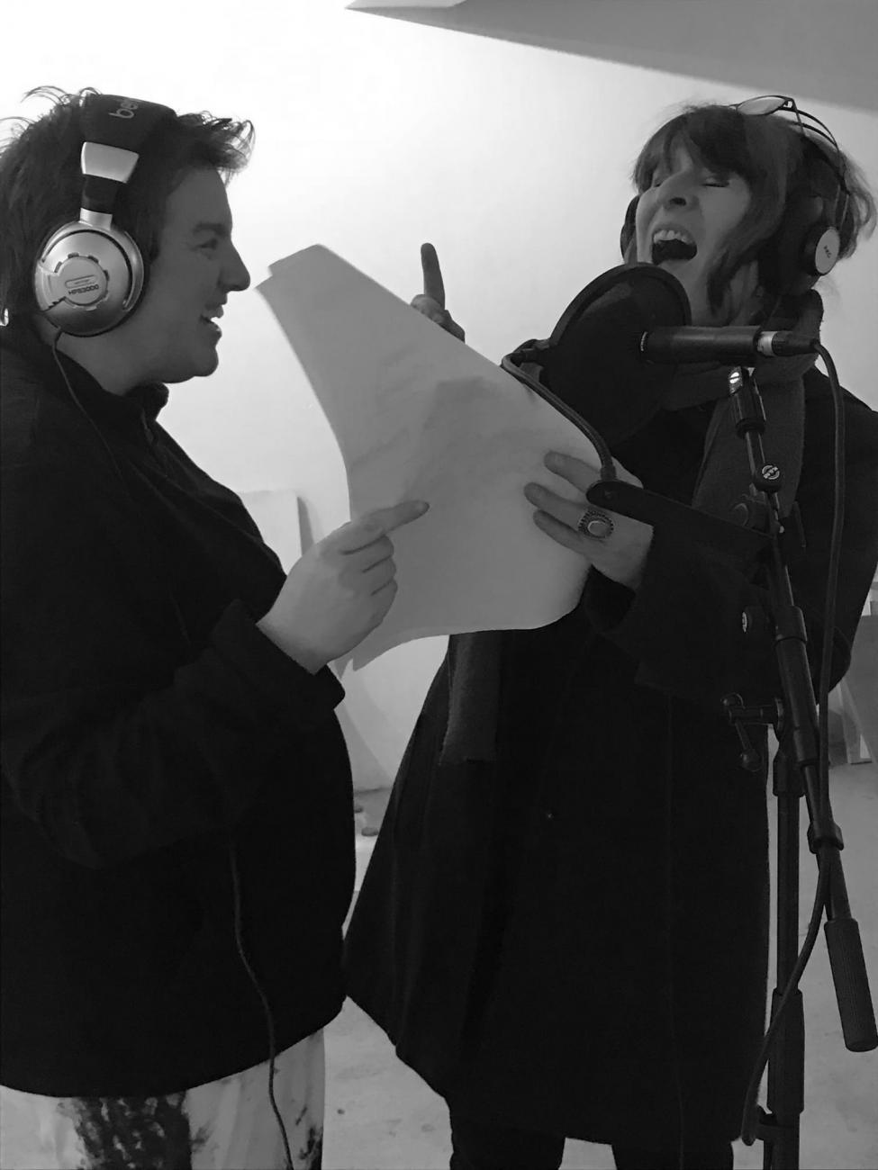2 people singing into a microphone 