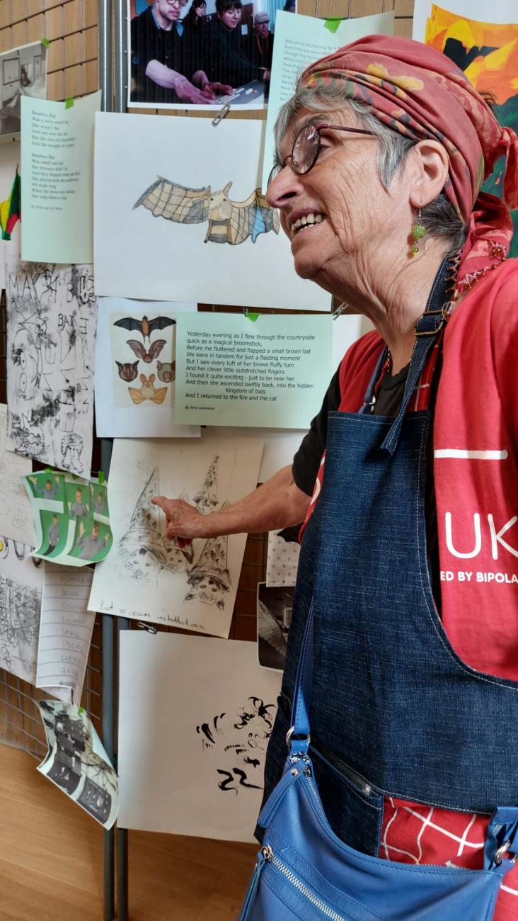 a person looking at a drawing hung on the wall